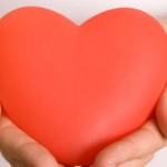 a red heart held in a person's hands