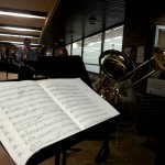 A brass ensemble plays in the hallway of extended education as students walk by