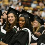 Two female students look at the camera with excitement and hope at Fall Convocation 2014