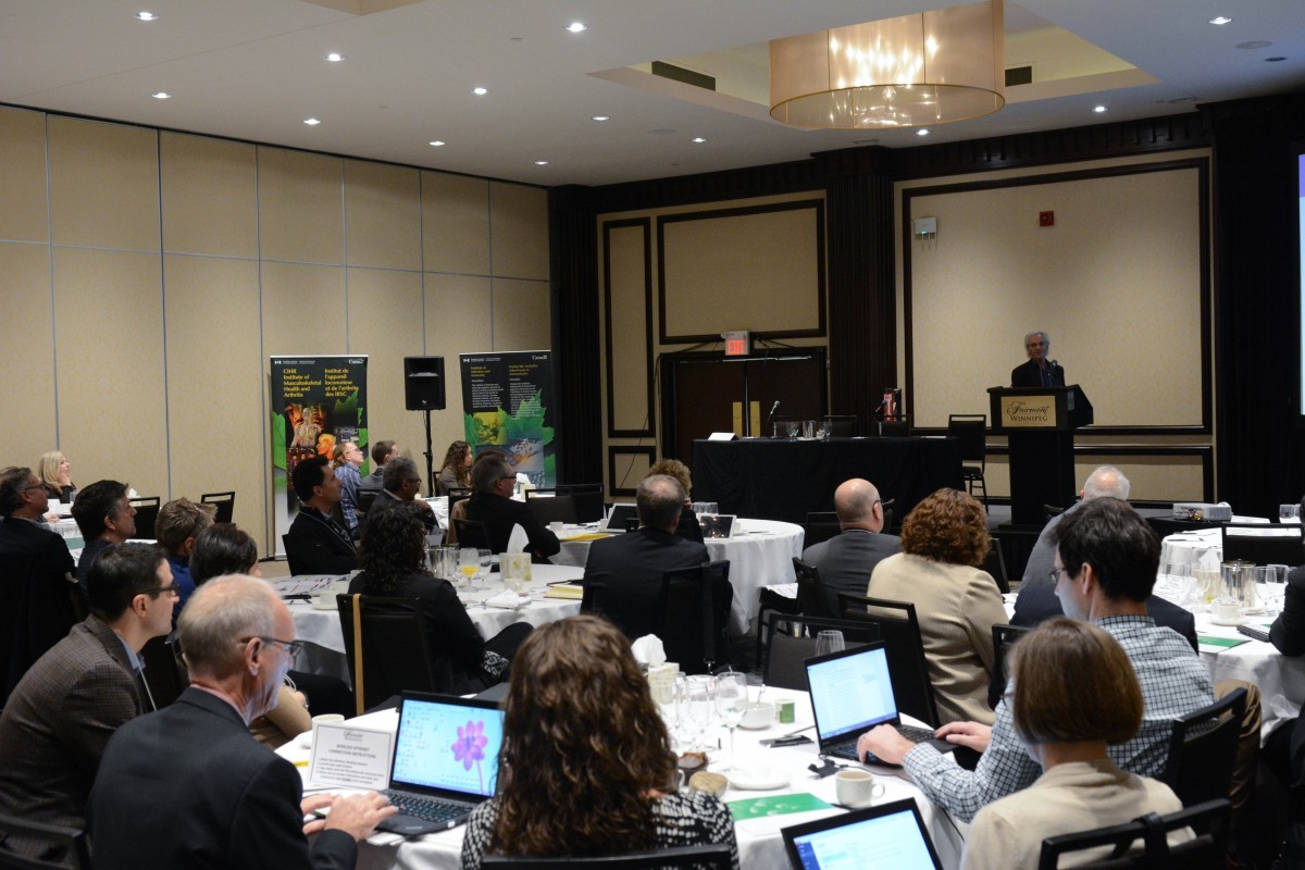 people in a meeting room at tables with laptops