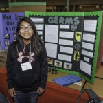 A student in front of her project, 'GERMS"