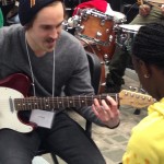 A U of M Jazz student (aka Jazz Buddy) mentors a participant in guitar technique during the CanU Jazz Academy.