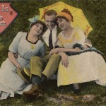 A hand tinted postcard from about 1910 shows a man between two women // Wikimedia