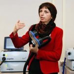 Zahra Moussavi holding a device capable of applying repetitive transcranial magnetic stimulation, which her new study will investigate as a therapy for Alzheimer’s patients.
