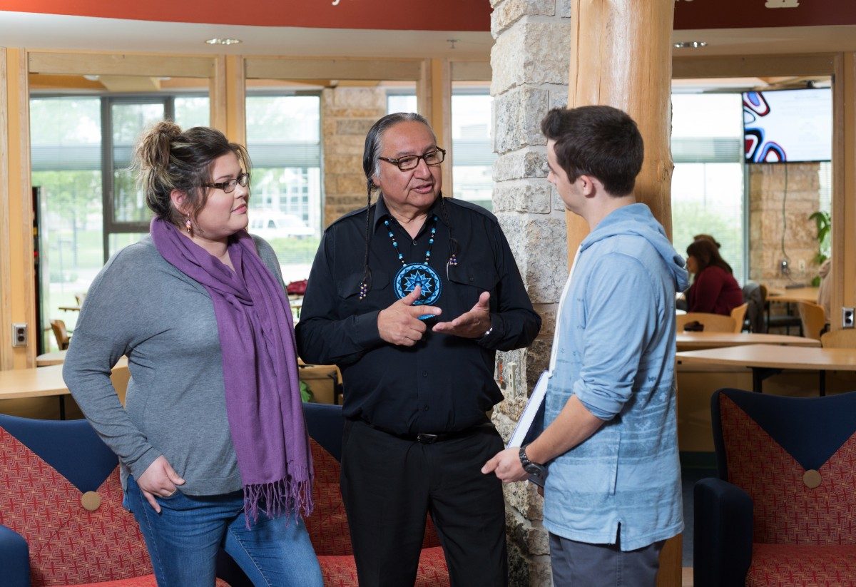 Indigenous students speak with Carl Stone in Migizii Agamik