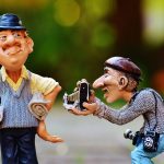 two sculptures of news reporters