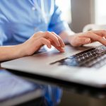 Close up of a female's hands typing on laptop