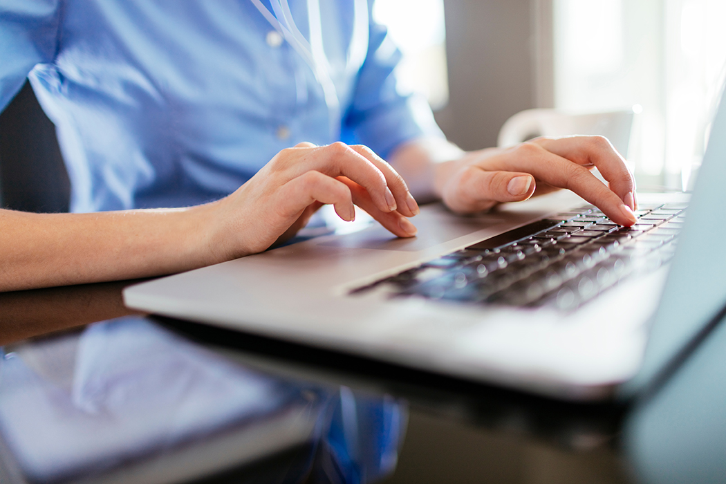 Close up of a female's hands typing on laptop