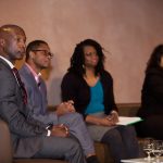 Panelists sitting on stage, looking engaged