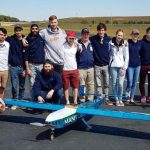 U of M students by their plane