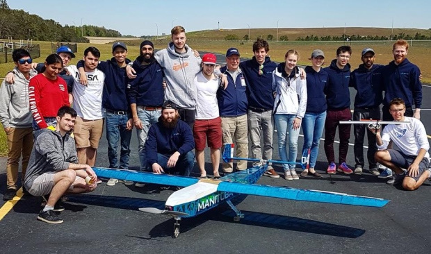 U of M students by their plane