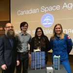 Dr. Philip Ferguson (mechanical engineering) and his graduate students Valorie Platero and Matthew Driedger, with CSA Astronaut Dr. Jenni Sidey, and a model of CubeSAT.