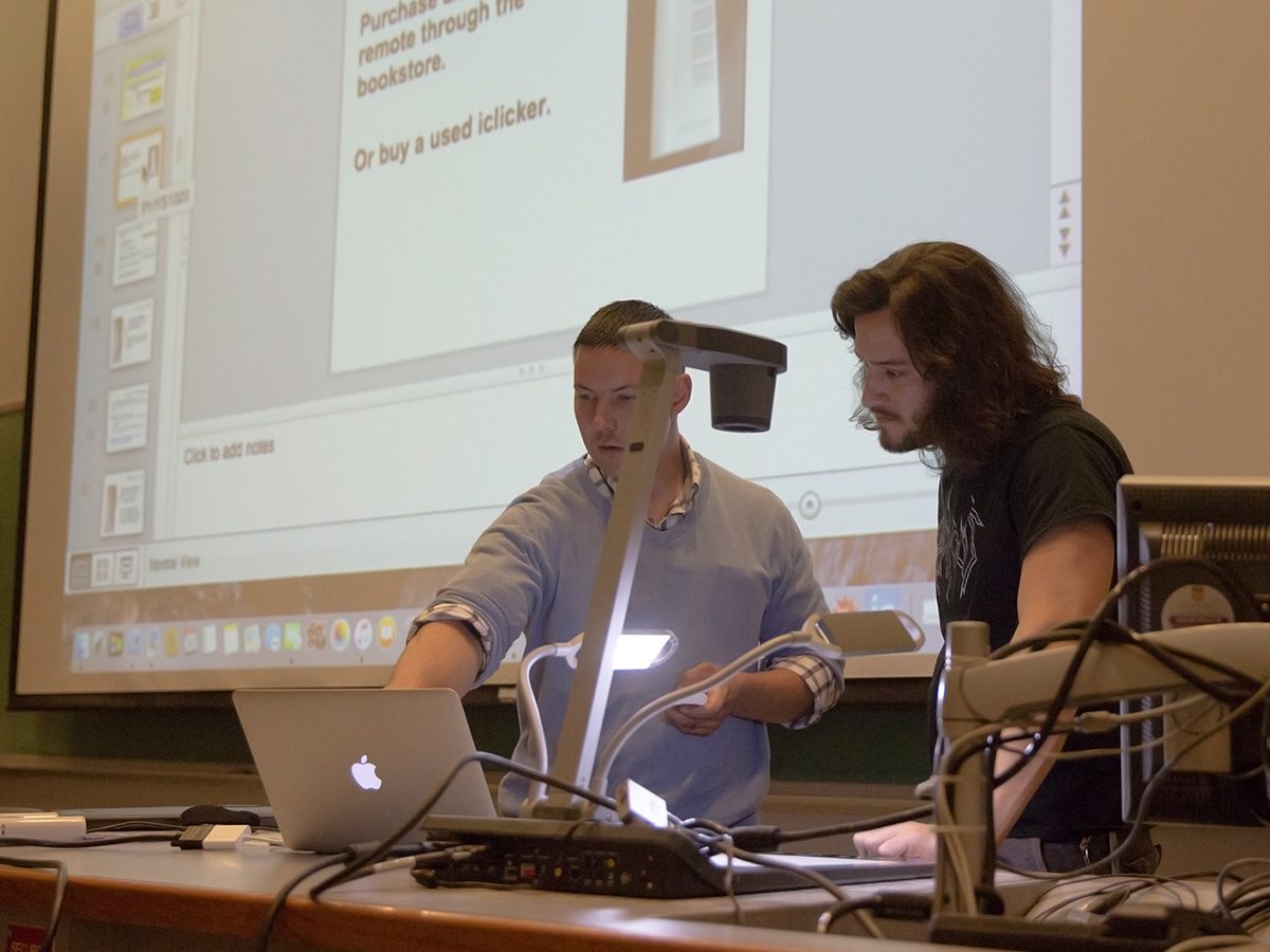 One man demonstating classroom technology to another