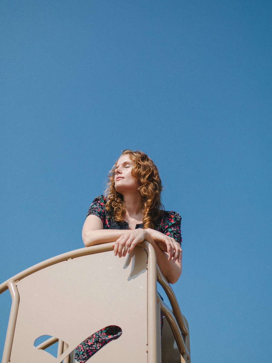 Angela Taylor stands in front of a clear blue sky