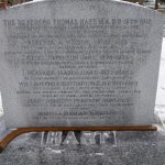A hockey stick at the base of a headstone