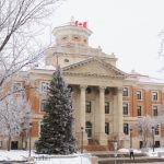 The U of M administration building flanked by snowy trees