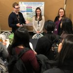 Students crowd around the Department of Medical Microbiology and Infectious Diseases booth at the Graduate Studies Open House.