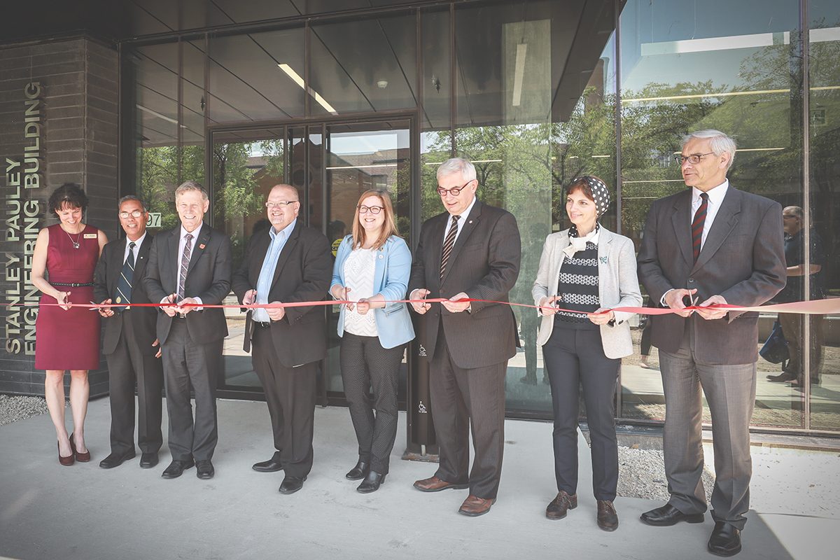 Left to right: Cutting the ribbon on the new Stanley Pauley Engineering Building Dr. Marcia Friesen (U of M), Dr. Digvir Jayas (U of M), Terry Duguid (Parliamentary Secretary & MP for Winnipeg South), The Honourable Kelvin Goertzen (Minister of Education, Province of Manitoba), Sarah Guillemard (MLA for Fort Richmond), President & Vice-Chancellor Dr. David Barnard (U of M), Dr. Zahra Moussavi (U of M), Dr. Jonathan Beddoes (Dean, Faculty of Engineering)