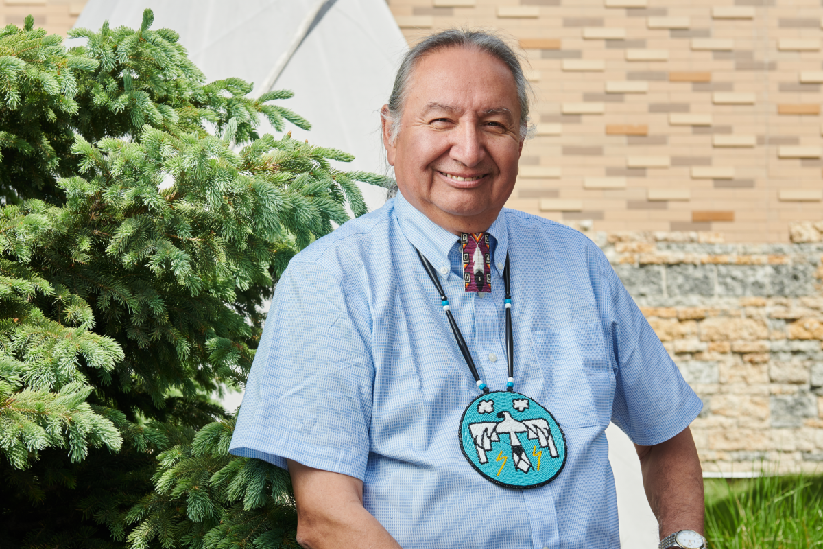 Carl Stone sits outside of Migizii Agamik - Bald Eagle Lodge