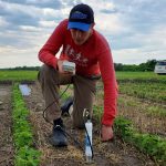PhD student Callum Morrison in field.