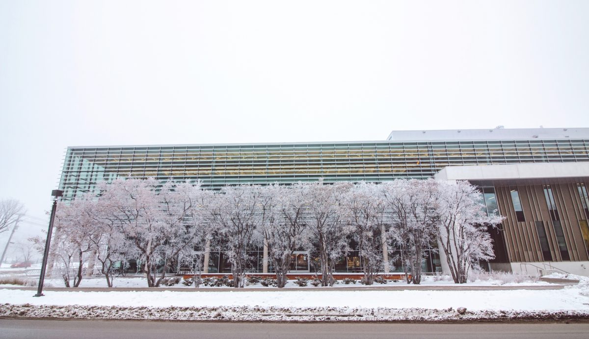 The exterior of the Active Living Centre. It's winter and there's frost and snow on a series of trees in front of the building.