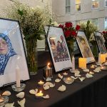 Photos of the plane crash victims are displayed on a table, with candles lit in front of the photos, at a vigil on Jan. 10, 2020.