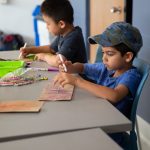 Child doing arts and crafts at Mini U