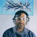 Nishant Balakrishnan wears his invention, clips attached to sunglass frames that hold a protective shield