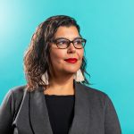 Dr. Marcia Anderson in front of a teal backdrop