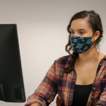 woman in mask at computer