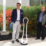 Researchers pose with telepresence robot