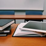 Books and computer tablet on classroom table