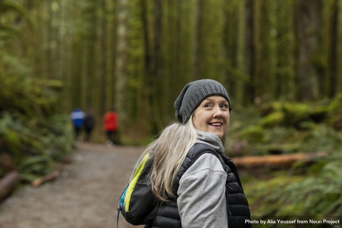 Smiling woman smiling and looking over her right shoulder by Alia Youssef from Noun Project