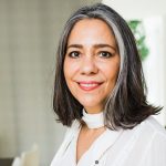 Mary Jane Maillet Brownscombe wearing a white shirt smiling at the camera.