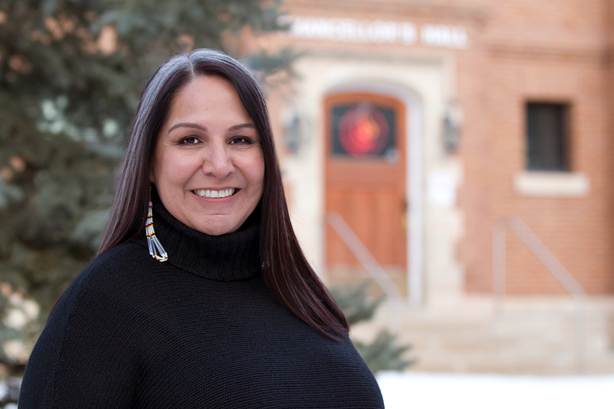 Stephanie Scott stands outside and the National Centre for Truth and Reconciliation is in the background.