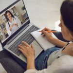 Patient speaks with a doctor via video chat on a laptop.