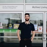 Bryden Bukich stands in front of UM's Faculty of Kinesiology and Recreation Management