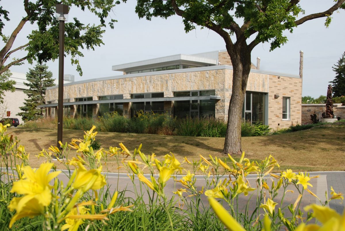 Migizii Agamik building with yellow flowers