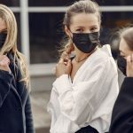 Three girls wear face masks.