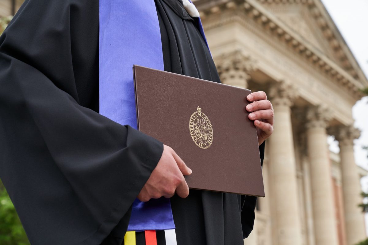 Person in grad gown holding degree
