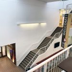 Birds eye view of a black and white staircase in the Asper School Drake building.