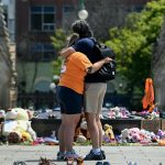 People embrace in front of the Centennial Flame on Parliament Hill at a memorial for the 215 children whose remains were found at the grounds of the former Kamloops Indian Residential School. // THE CANADIAN PRESS/Justin Tang
