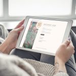 A person reads the UM website on a tablet computer