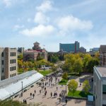 An aerial image of Fort Garry campus, looking south was people walk below.