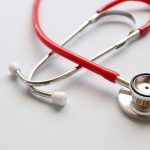 Red stethoscope on table.