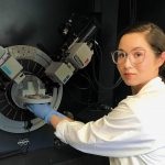 Rachel Nickel poses with a large scientific device.