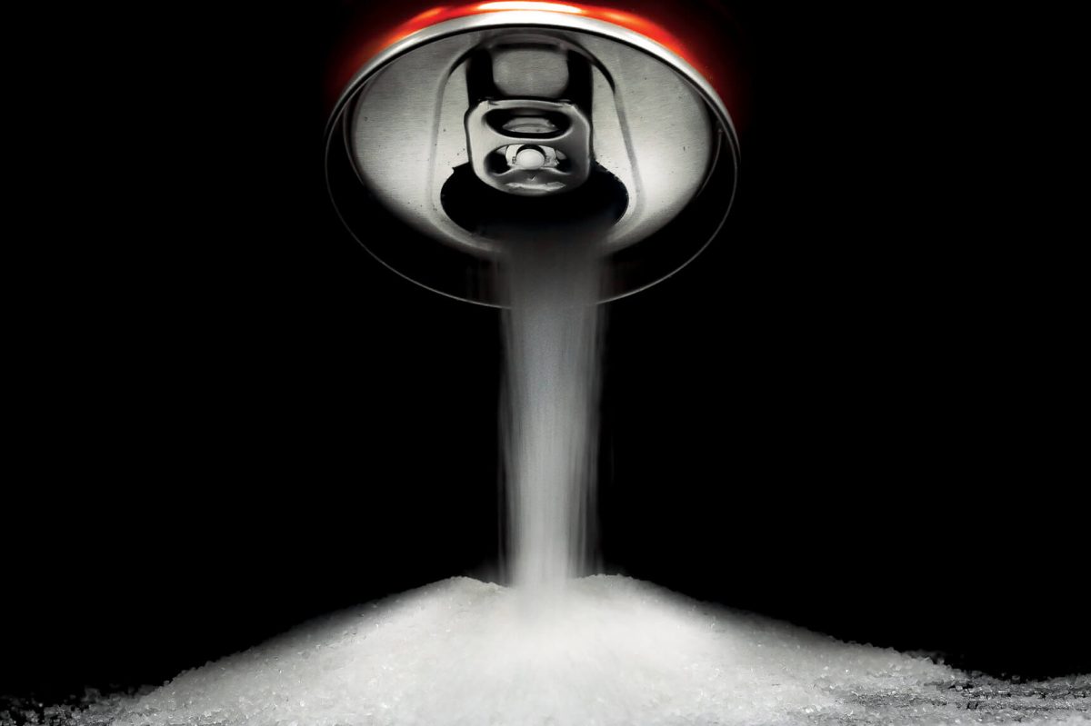 A pile of sugar pours out of a soda can.