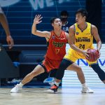 Binh Nguyen plays defense against a player holding the ball.