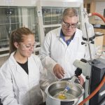 Professor Xidos and research student in a lab