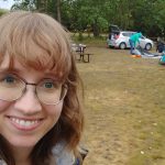 Angela Woodbury in font of a campsite.